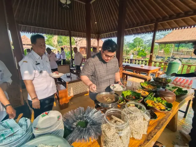 Pengunjung menikmati sajian prasmanan di antara tiang kayu pendopo.